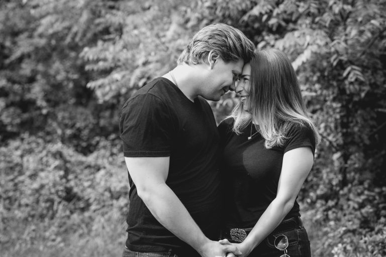 Sarah and Ryan embracing outdoors during their engagement photo session near the Comus Inn
